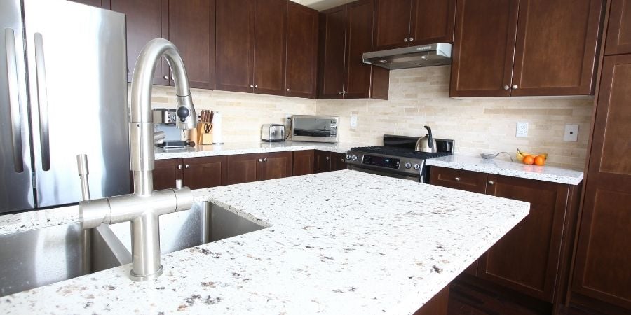 engineered white quartz countertop with dark brown cabinets