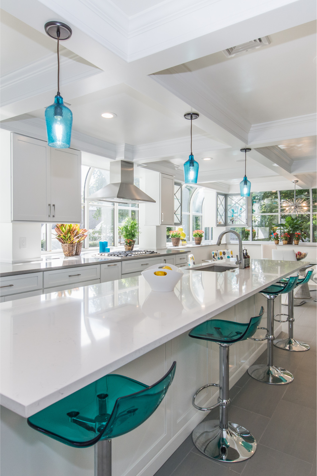 Modern kitchen remodel with white quartz countertops, stainless steel appliances, curved windows, and updated lighting fixtures. Modern kitchen remodel with white quartz countertops, stainless steel appliances, curved windows, and updated lighting fixtures.