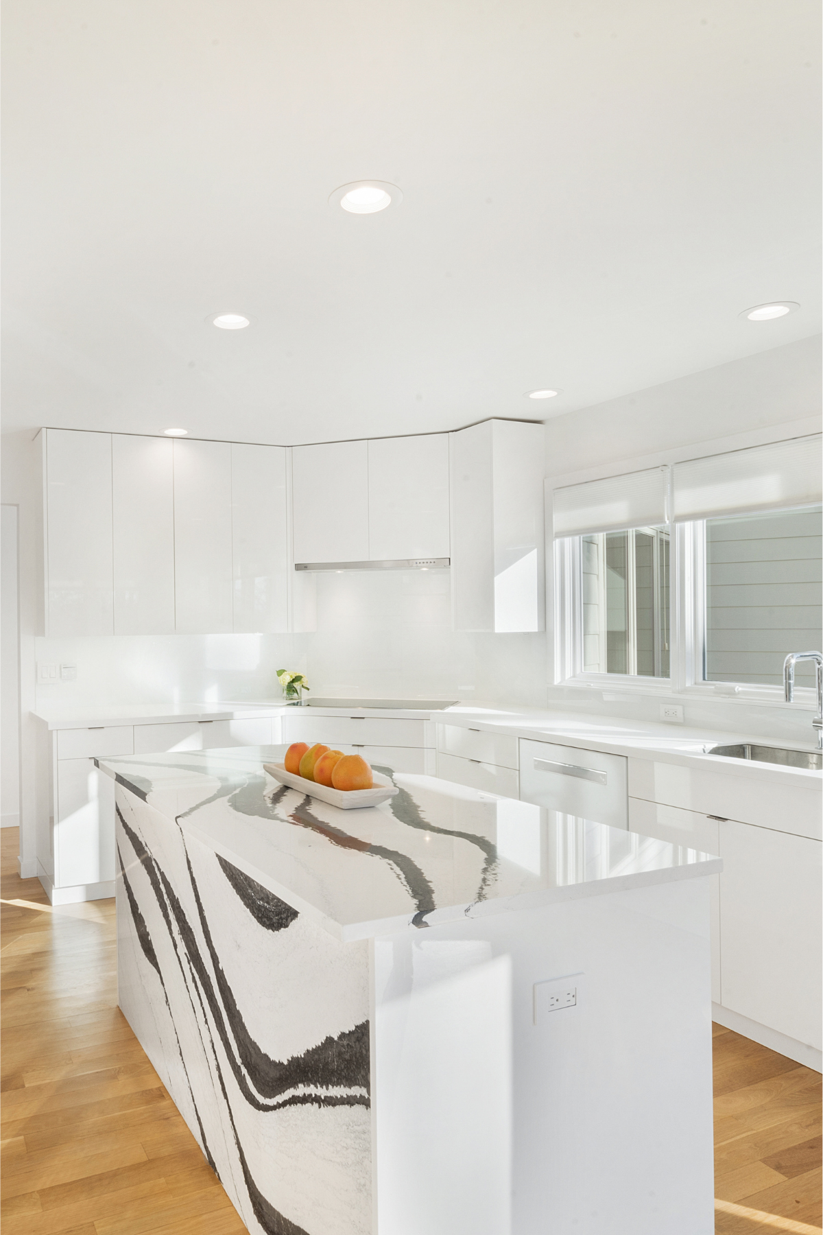 Seamless all-white kitchen with clean lines and floor-to-ceiling windows that flood the space with natural light for a bright, airy atmosphere Seamless all-white kitchen with clean lines and floor-to-ceiling windows that flood the space with natural light for a bright, airy atmosphere