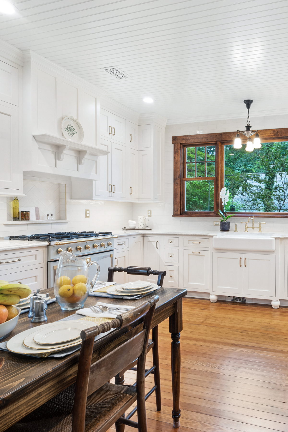 “Farmhouse-style kitchen featuring warm wood floors, a classic farmhouse sink, and a striking blue oven for a charming, rustic-modern look. “Farmhouse-style kitchen featuring warm wood floors, a classic farmhouse sink, and a striking blue oven for a charming, rustic-modern look.