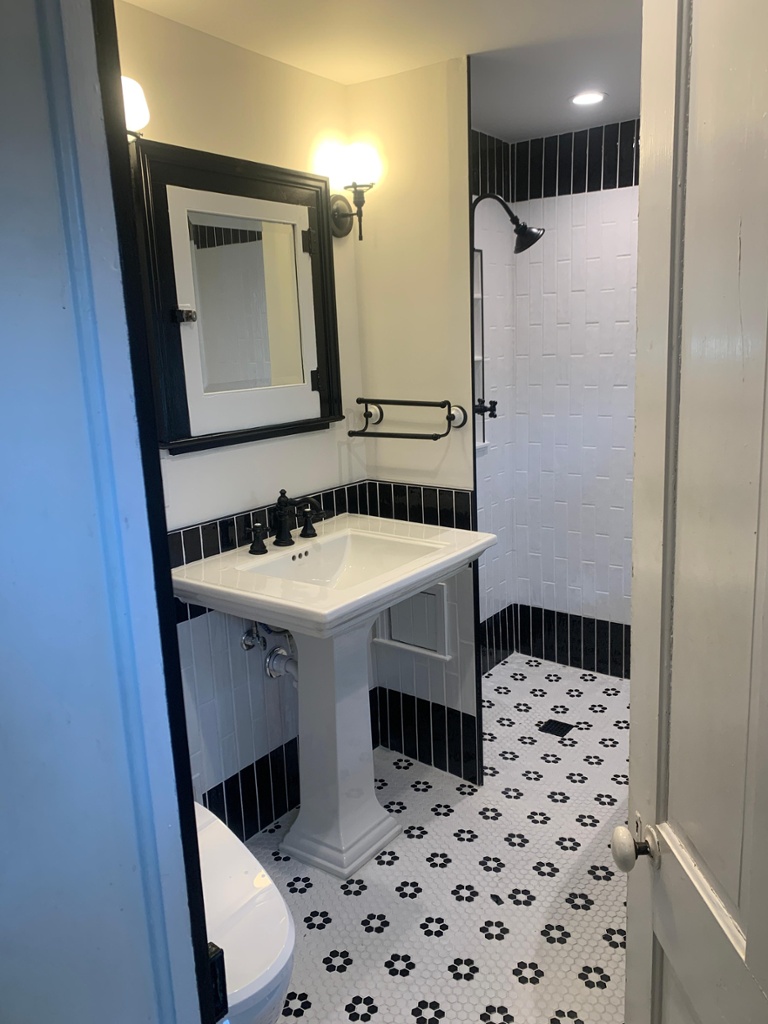 Vintage black & white soaking claw foot tub with pedestal sink in Boonton Renovated by JMC