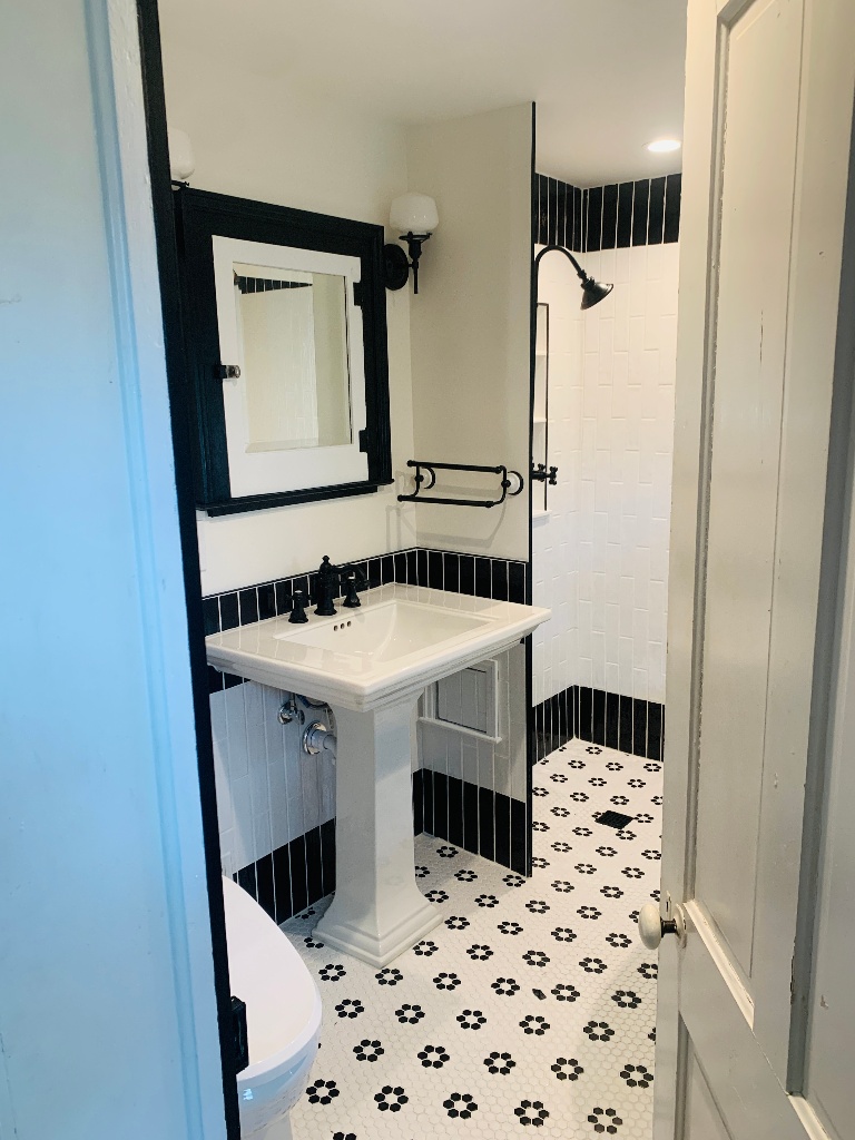 Vintage black & white soaking claw foot tub with pedestal sink in Boonton Renovated by JMC