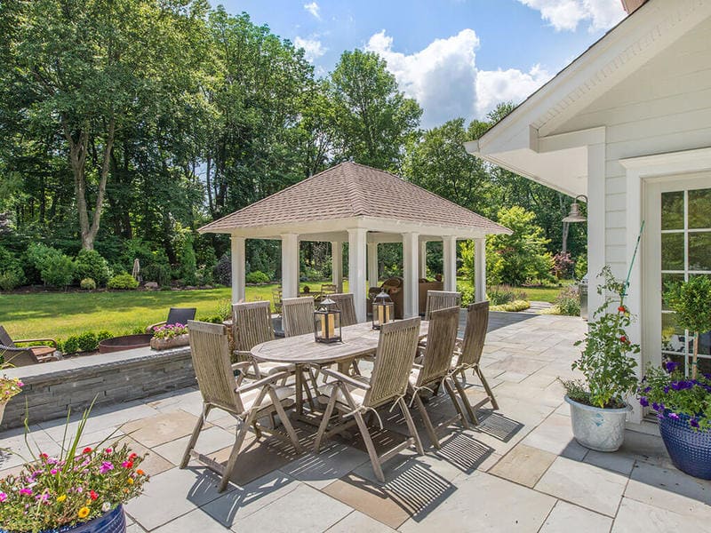 Blue stone patio with pavilion with custom traditional paneled columns and open ceiling and outdoor dining in Boonton, NJ renovated by JMC Home Improvement Specialists