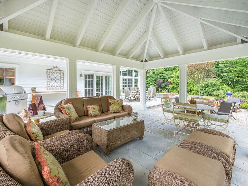 Pavilion with open vaulted ceiling, indirect lighting, 3x10 rustic rafters with custom traditional paneled columns on blue stone patio in Boonton, NJ renovated by JMC Home Improvement Specialists