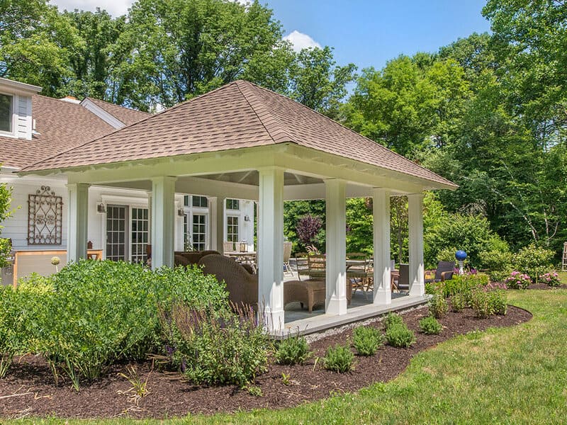 Pavilion with tongue and groove roof decking, white custom traditional paneled columns on blue stone patio with garden in Morris County, New Jersey renovated by JMC Home Improvement Specialists