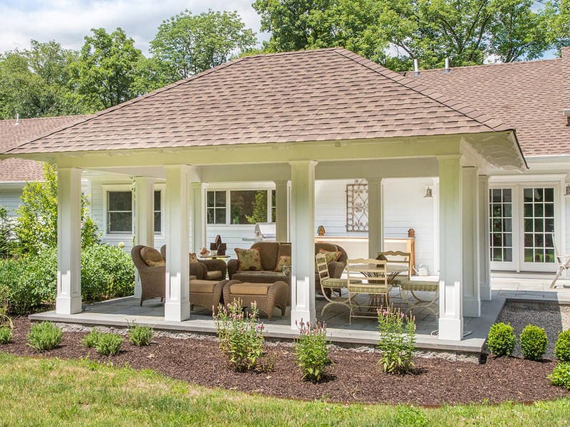 Exterior custom pavilion with tongue and groove roof decking, white custom traditional paneled columns on blue stone patio with garden in Boonton, New Jersey remodeled by JMC Home Improvement Specialists