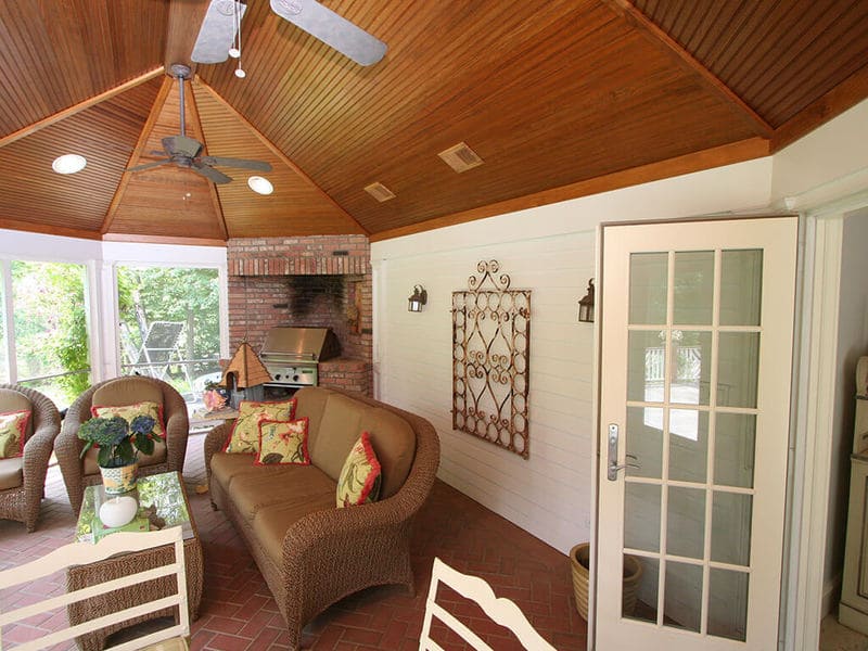 Screened in porch with vaulted hip beadboard ceiling, stained pine with French door, highhat lights, brick floor and built-in brick natural gas grill in Mt Lakes, NJ remodeled by JMC Home Improvement Specialists