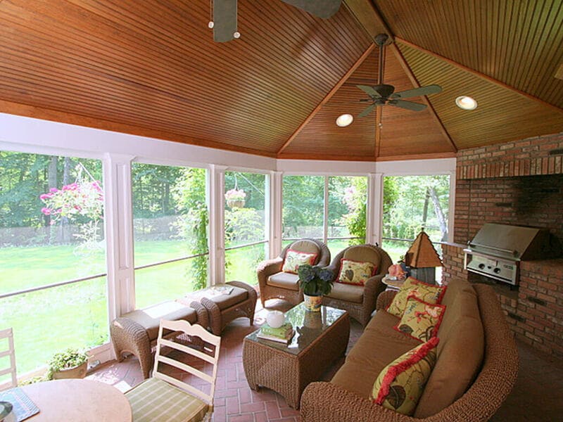 Screened in porch with Andersen windows and hidden screen panels, beadboard ceiling, decorative columns, brick floor and brick built-in natural gas grill in Mountain Lakes, New Jersey remodeled by JMC Home Improvement Specialists