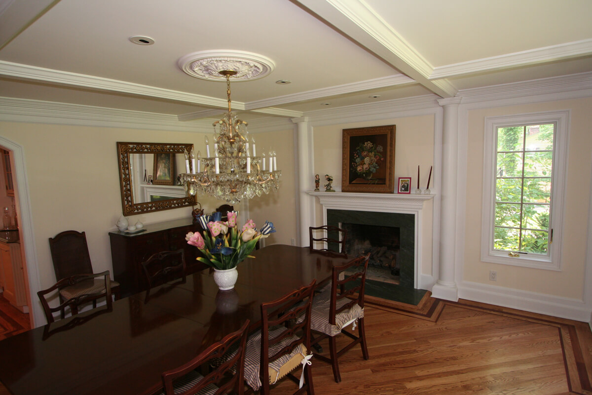 Dining room with fireplace, chandelier and wall panel and decorative columns Mountain Lakes, NJ renovated by JMC Home Improvement Specialists