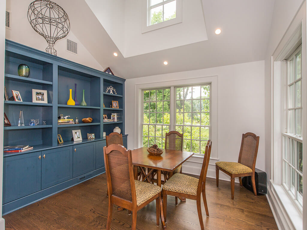 Custom blue wall unit in rustic Family room remodel with 7” oak plank flooring, architectural clear story dormer with Andersen windows in Boonton, NJ renovated by JMC Home Improvement Specialists