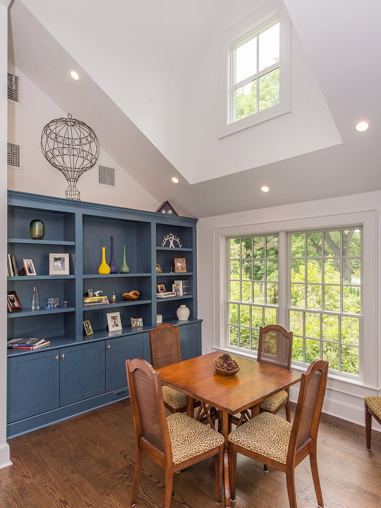 Blue custom wall unit in rustic Family room remodel with 7” oak plank flooring, vaulted ceiling and architectural clear story dormer with Andersen windows in Boonton, NJ renovated by JMC Home Improvement Specialists