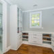 Custom white master bedroom walk-in closet with shelving and drawers, hardwood floor and entrance to master bathroom In Springfield, New Jersey renovated by JMC Home Improvement Specialists