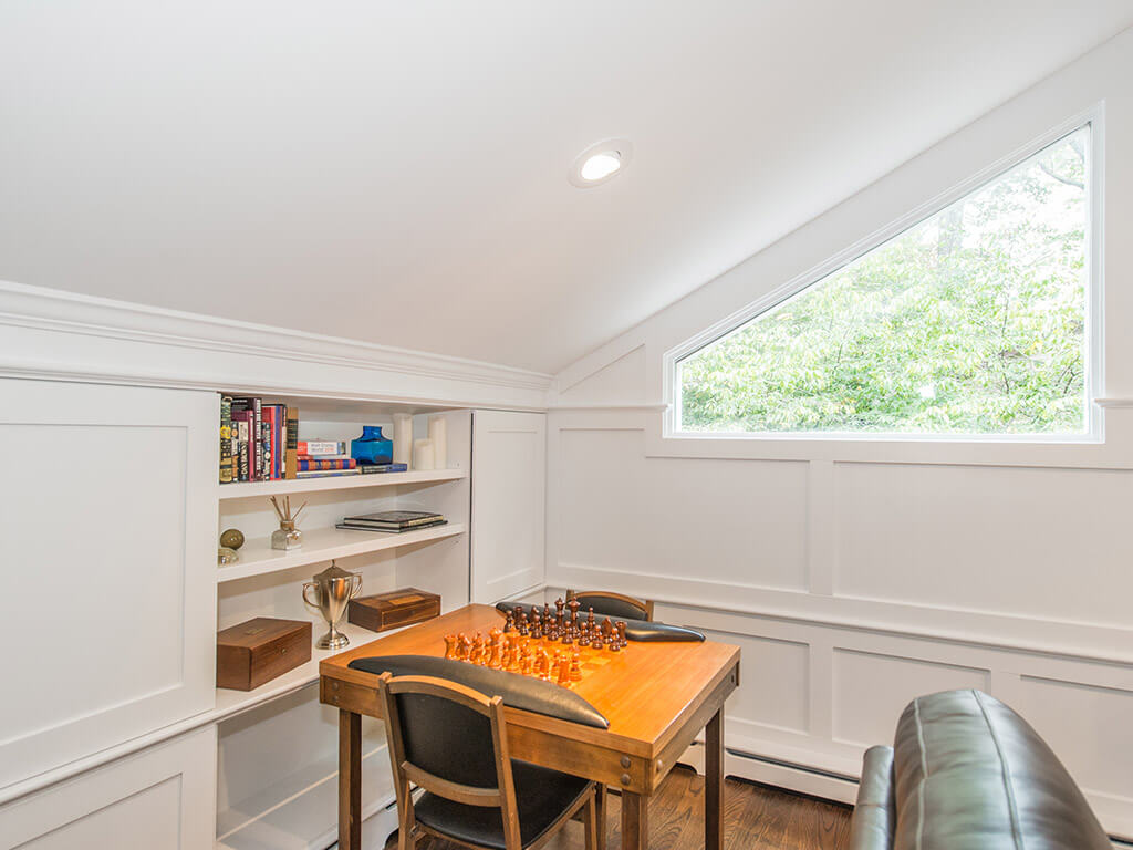 Custom wood paneling around window and shelving with game area in family room In Randolph, New Jersey renovated by JMC Home Improvement Specialists