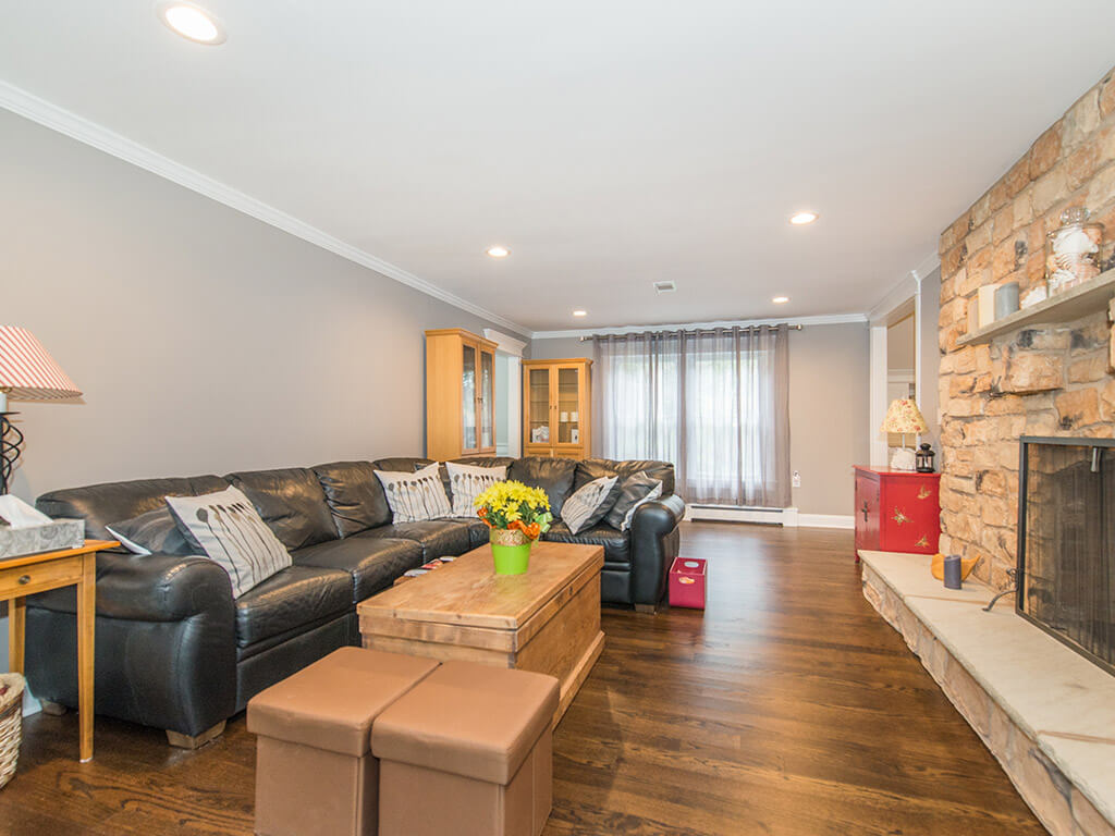 Living room with stone fireplace, led high hats and hardwood floor In Randolph, New Jersey renovated by JMC Home Improvement Specialists