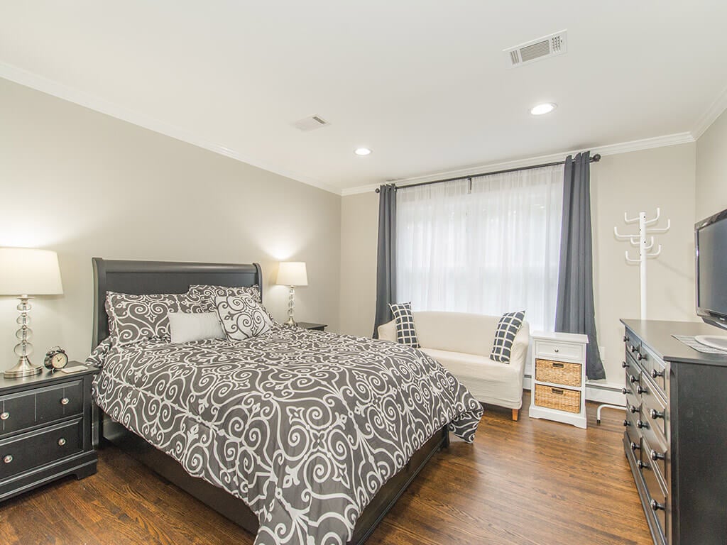 Gray bedroom with hardwood flooring and led high hats In Randolph, New Jersey renovated by JMC Home Improvement Specialists