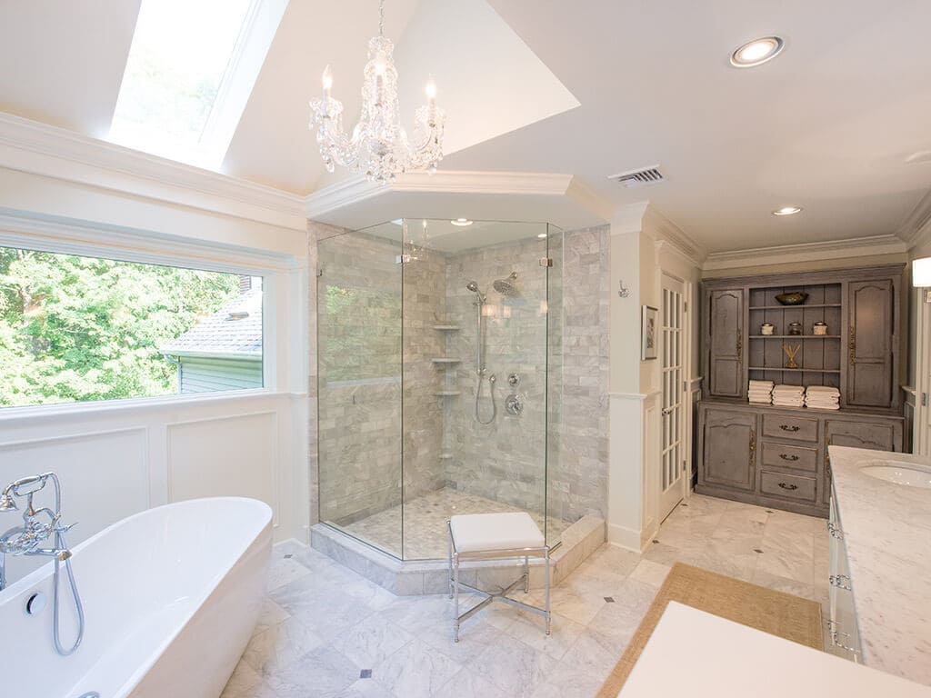Soaking tub and frameless glass walk-in shower with Carrera marble with Custom gray cabinets in white master bath Sparta, NJ Renovated by JMC Home Improvement Specialists