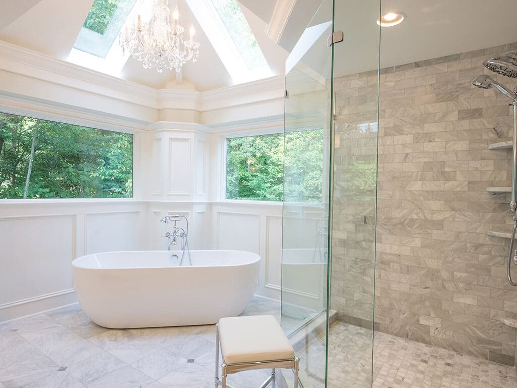 Vaulted Ceiling with skylight, freestanding soaking tub with walk-in shower with frameless glass and Carrera marble white master bath in Sparta, NJ Renovated by JMC Home Improvement Specialists