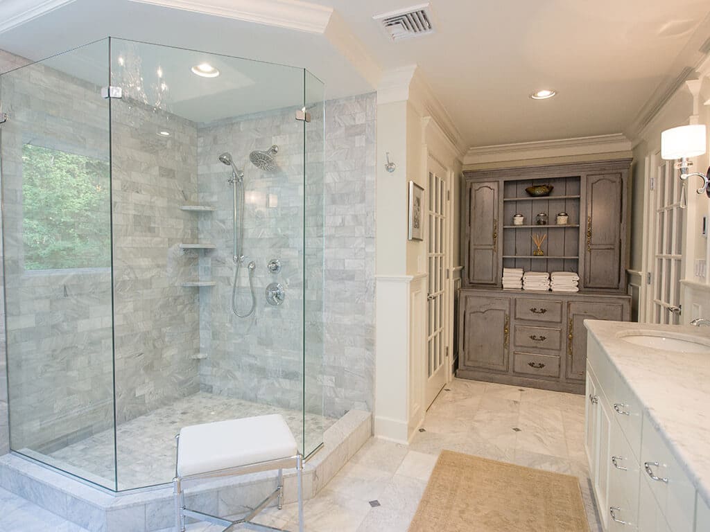 Custom gray cabinets in white master bath with frameless glass walk-in shower with Carrera marble in Sparta, NJ Renovated by JMC Home Improvement Specialists