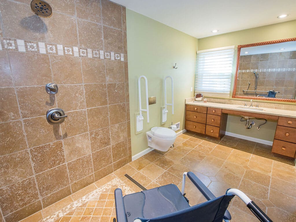 Handicap bathroom remodel with roll in shower with marble mosaic floor and in wall toilet in Morristown, NJ renovated by JMC Home Improvement Specialists