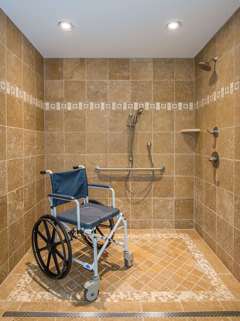 Handicap bathroom remodel wheelchair roll in shower with marble tile mosaic floor and linear shower drain in Morristown, NJ renovated by JMC Home Improvement Specialists