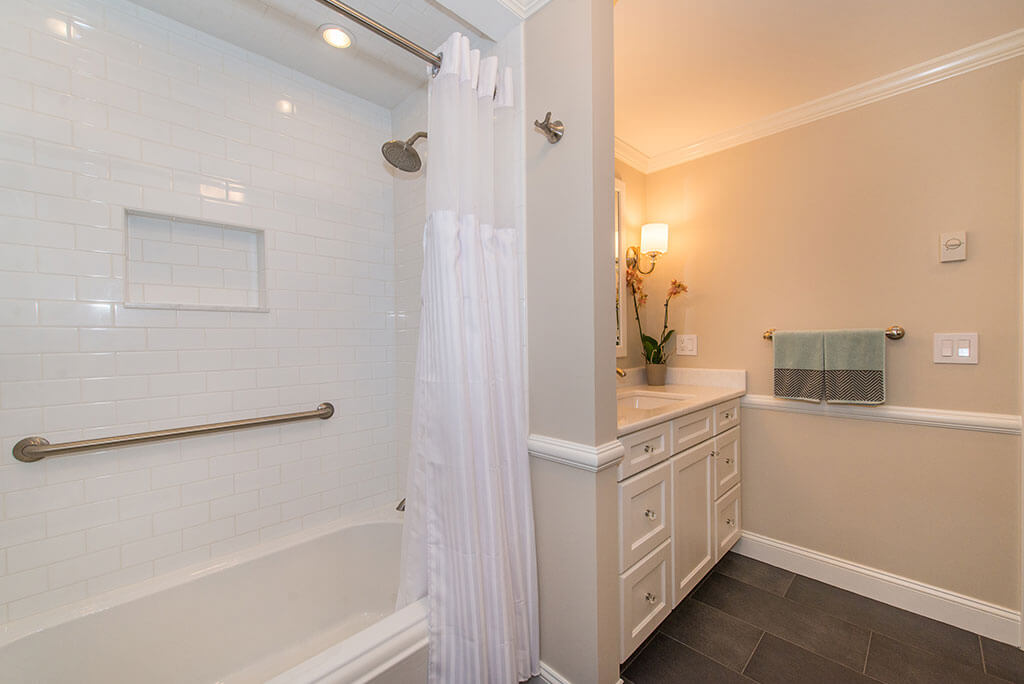 Hall bathroom remodel with white vanity, shower with subway tile, grab bar, niche, shower curtain and tub, with crown molding in Boonton, NJ renovated by JMC Home Improvement Specialists Hall bathroom remodel with white vanity, shower with subway tile, grab bar, niche, shower curtain and tub, with crown molding in Boonton, NJ renovated by JMC Home Improvement Specialists