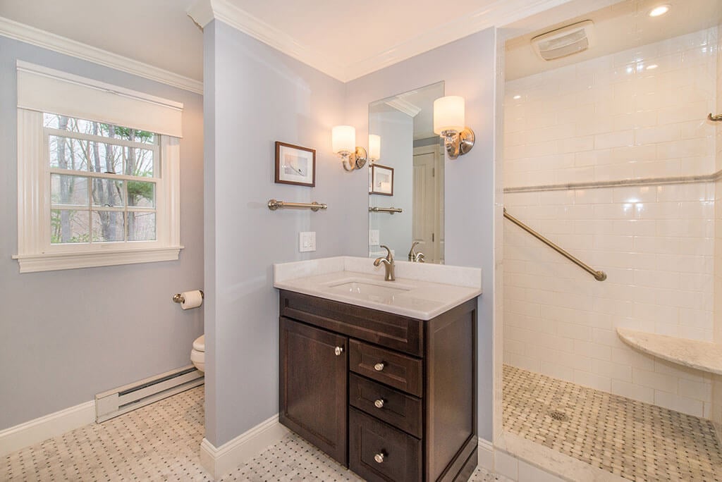 Boonton, NJ Master bathroom remodel corner espresso vanity with Carrera marble top, corner seat in shower with subway tile and grab bars, and basketweave floor renovated by JMC Home Improvement Specialists