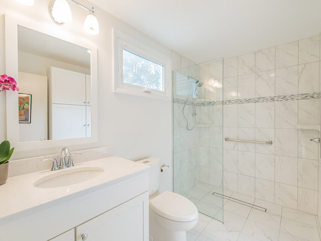 White handicap bathroom remodel with roll in shower, linear drain with mosaic tile and grab bar in Mount Tabor, NJ renovated by JMC Home Improvement Specialists