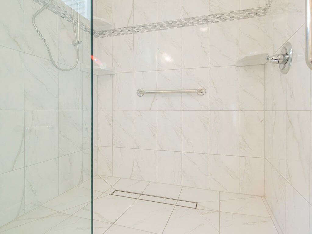 White handicap bathroom remodel with roll in shower, linear drain with mosaic tile and grab bar and handheld in Mt Tabor, NJ renovated by JMC Home Improvement Specialists