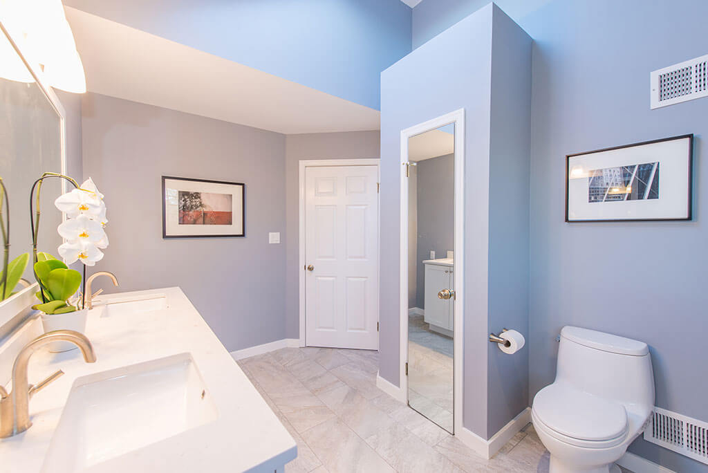 Master bathroom remodel in Chatham, NJ with linen closet and dual white marble countertop with framed mirror renovated by JMC Home Improvement Specialists