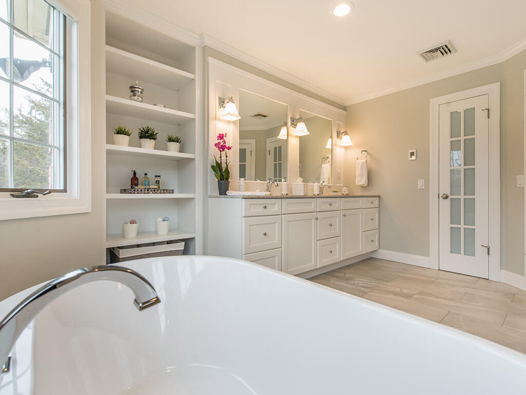 White master bathroom remodel with shaker cabinet vanity with quartz counter, soaking tub, built-in bookcase and linen storage closet in Green Township, NJ renovated by JMC Home Improvement Specialists 