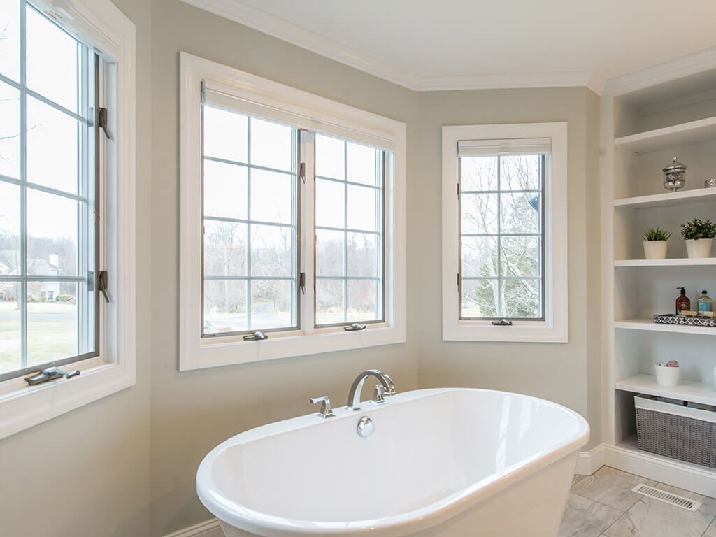 Elegant master bathroom remodel with soaking tub, Andersen windows and custom built-in bookshelf in Morris County, NJ renovated by JMC Home Improvement Specialists 