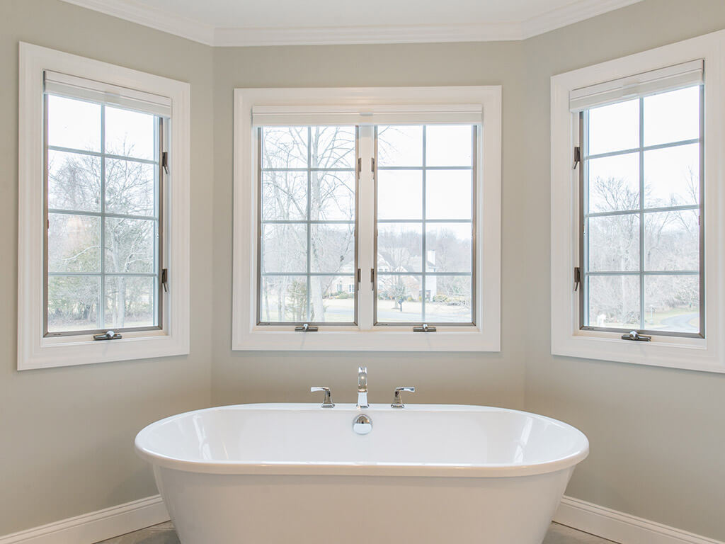 Elegant master bathroom remodel soaking tub surrounded by Andersen windows with white trim Morris County, NJ renovated by JMC Home Improvement Specialists 