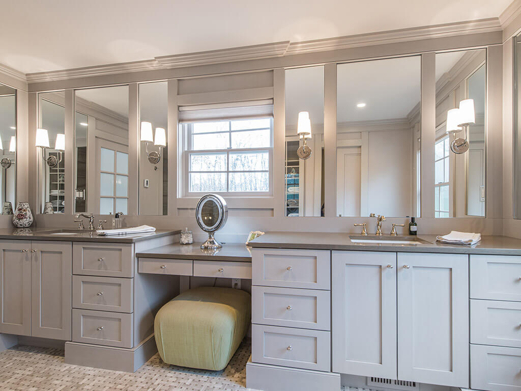 Award winning master bathroom remodel with monochromatic taupe, basket weave tile, make-up table, separate his and her shaker cabinet vanities, custom wood framed mirrors with sconces  and crown molding in Boonton, NJ renovated by JMC Home Improvement Specialists