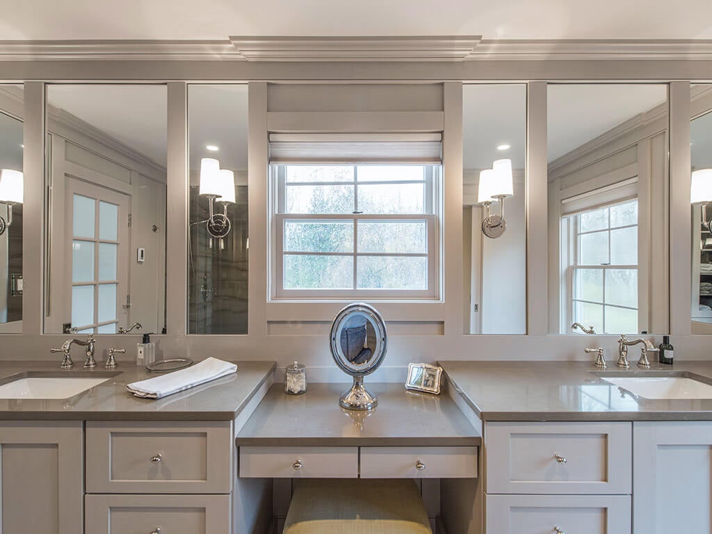 Master bathroom remodel with monochromatic taupe, basket weave tile, make-up table, separate his and her shaker cabinet vanities, custom wood framed mirrors with sconces  and crown molding in Boonton, NJ renovated by JMC Home Improvement Specialists