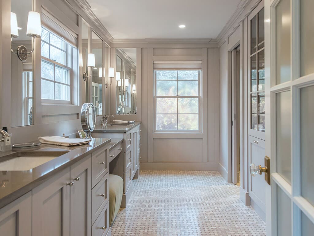 Elegant award winning master bathroom remodel with frosted glass door, separate vanities, heated basketweave floor, custom wood framed mirrors, monochromatic taupe in Boonton, NJ renovated by JMC Home Improvement Specialists