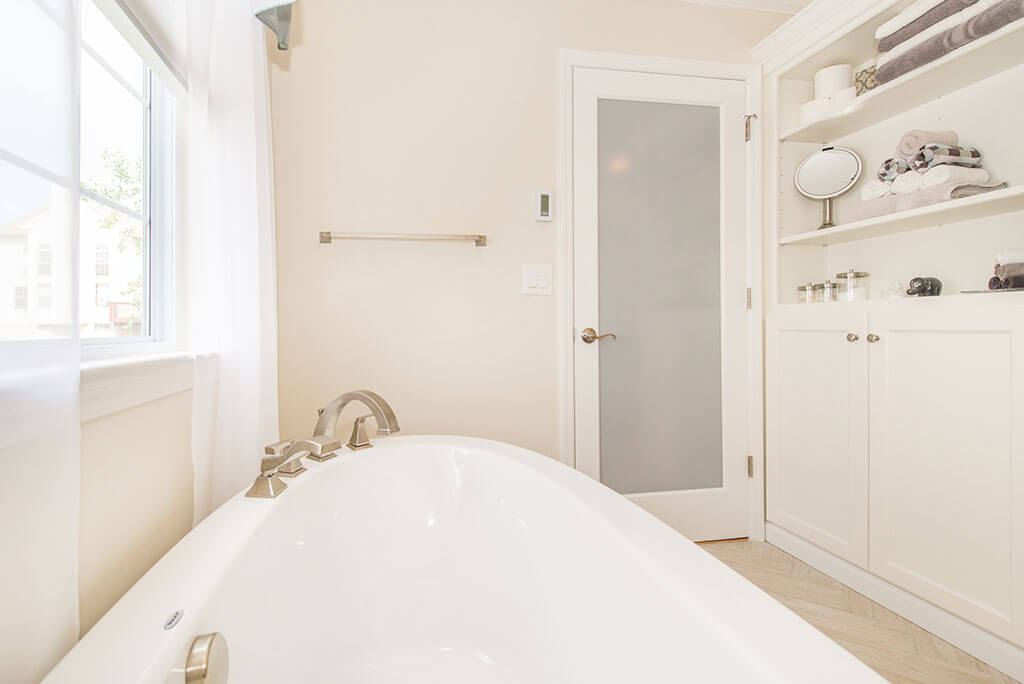 Master bathroom remodel with soaking tub, frosted glass door, open shelving and white shaker linen cabinet with brushed nickel finishes in Lake Hopatcong, NJ renovated by JMC Home Improvement Specialists