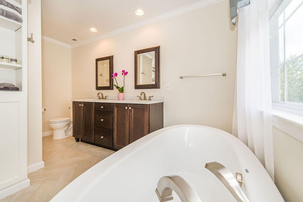 Master bathroom remodel with crown molding, his and hers vanity, granite counters, wood framed mirrors soaking tub with brushed nickel finishes in Lake Hopatcong, NJ renovated by JMC Home Improvement Specialists