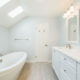 White master bathroom remodel with vaulted ceilings, skylight for natural light, his and hers vanity, white framed mirrors and soaking tub in Madison, NJ renovated by JMC Home Improvement Specialists
