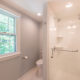 Master bathroom remodel with clear glass shower door, white subway tile and corner shelves in shower and grey painted walls in Mendham, NJ renovated by JMC Home Improvement Specialists