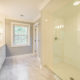 Master bathroom remodel in Morristown, NJ with white subway tile in shower with clear glass panel, quartz counters and grey painted walls with white crown molding renovated by JMC Home Improvement Specialists