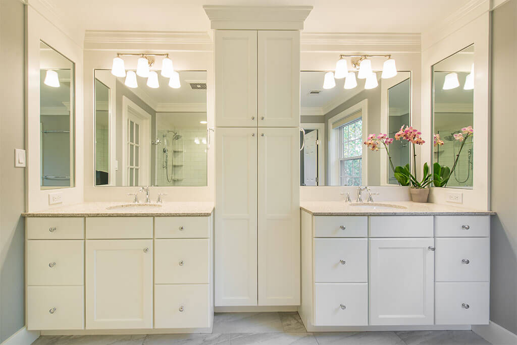 Master bathroom remodel with his and hers separate white vanities, quartz counters, linen cabinet with white crown molding in Morristown, NJ renovated by JMC Home Improvement Specialists