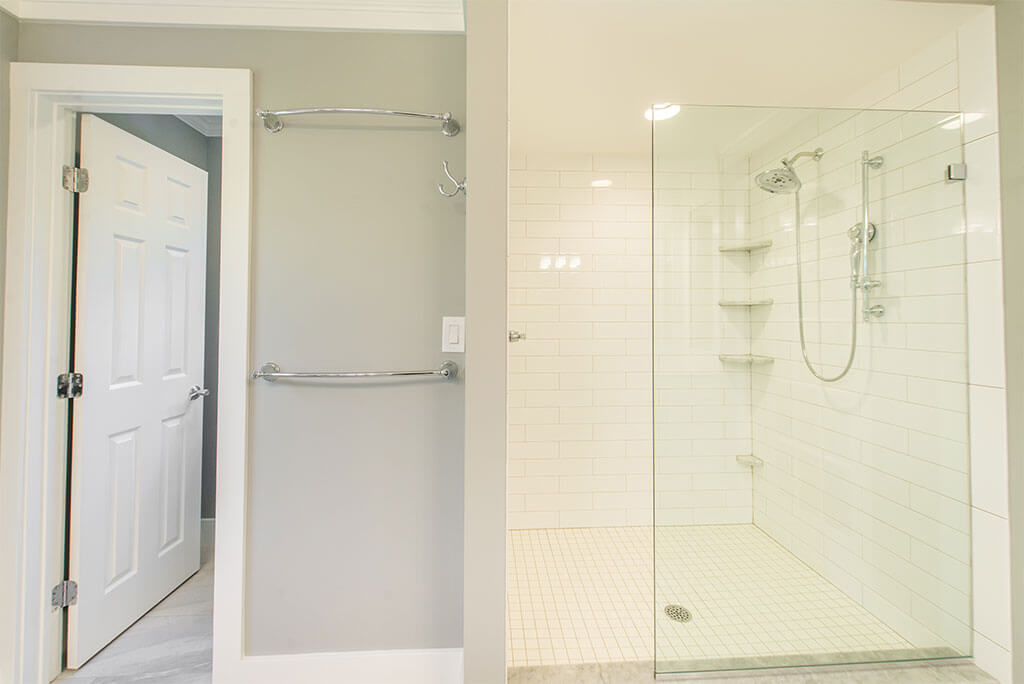 Master bathroom remodel in Morristown, NJ with curbless walk-in shower with white subway tile, clear glass panel, corner shelves, chrome finishes renovated by JMC Home Improvement Specialists