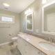 Hall bathroom remodel with his and hers white vanities, white framed mirrors, tub and curved curtain with white subway tile and grey painted walls  in Morristown, NJ renovated by JMC Home Improvement Specialists