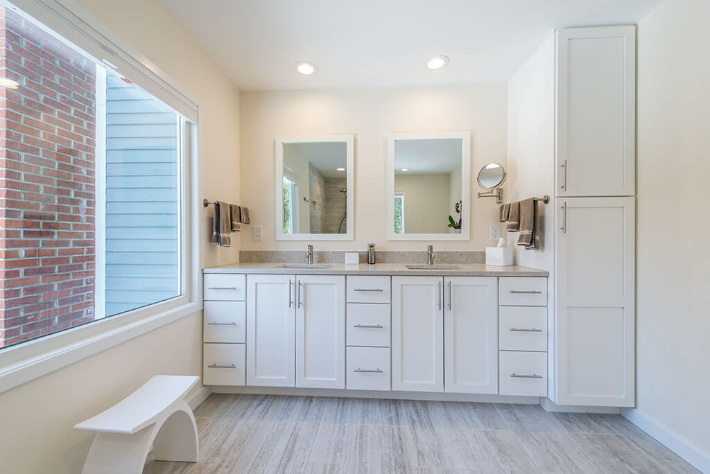 Master bathroom remodel with white shaker his and hers vanity with quartz counters and white framed mirrors, large window and linen cabinet in Chester, NJ renovated by JMC Home Improvement Specialists