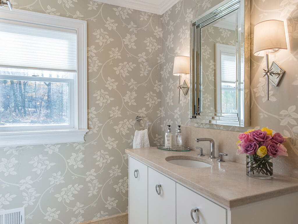 Hall bathroom remodel with decorative wallpaper, crown molding, free standing vanity with flush white doors and framed mirror in Boonton, NJ renovated by JMC Home Improvement Specialists