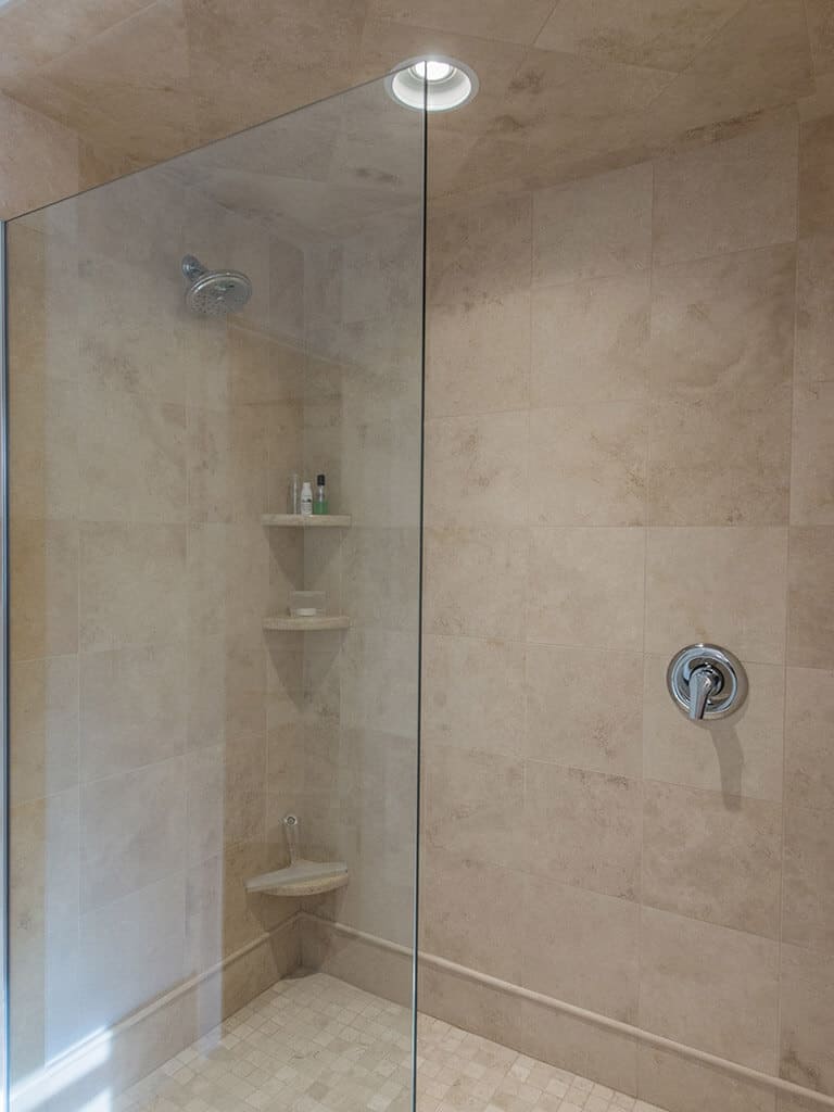 Hall bathroom remodel glass panel shower door with corner shelves and chrome finishes in Boonton, NJ renovated by JMC Home Improvement Specialists