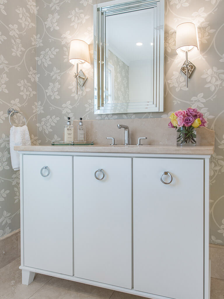 Hall bathroom remodel with decorative wallpaper, marble, free standing vanity with flush white doors, framed mirror, decorative lighting and chrome finishes in Boonton, NJ renovated by JMC Home Improvement Specialists