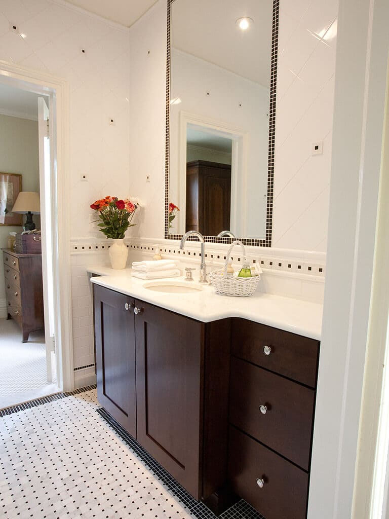 Master bathroom remodel with espresso and marble vanity, tile around mirror, basketweave floor, black and white Carrera tiles in Morristown, NJ renovated by JMC Home Improvement Specialists