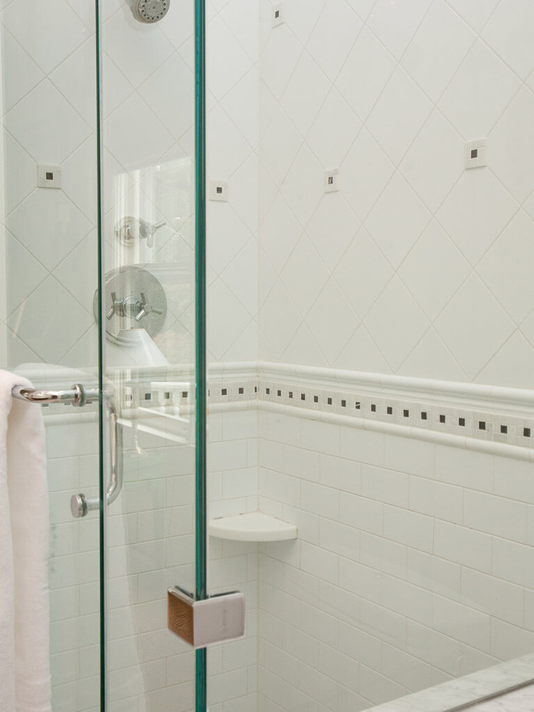 Master bathroom remodel clear glass panel shower door, chrome finishes,  black and white Carrera tiles in Morristown, NJ renovated by JMC Home Improvement Specialists