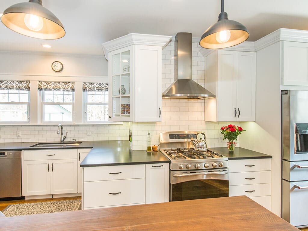 Farmhouse kitchen remodel with hardwood flooring, white shaker cabinets, quartz counters and concrete countertop on island, stainless undermount sink, freestanding hood ss appliances in Morristown, NJ renovated by JMC Home Improvement Specialists